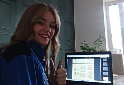 A young Ukrainian Refugee gives a 'thumbs up' as she uses the Word360 language support guide on a laptop to help her adapt to life in the UK