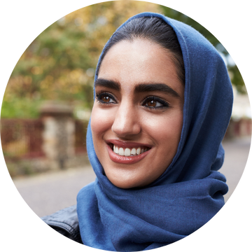 Woman wearing a blue headscarf smiling as a happy Word360 customer