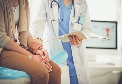 A Black Country NHS trust doctor holding a patients hand while reading out their results