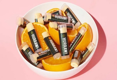 Hurraw beauty products in a bowl with oranges
