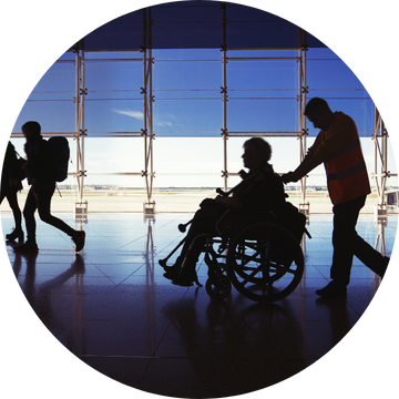 NHS employee helping a disabled patient at an airport