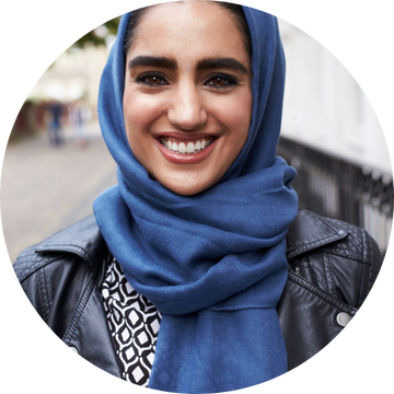 A smiling Asian woman wearing a blue headscarf