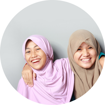 Two Asian girls in headscarf's smiling as they got the help they needed from Ovacome 